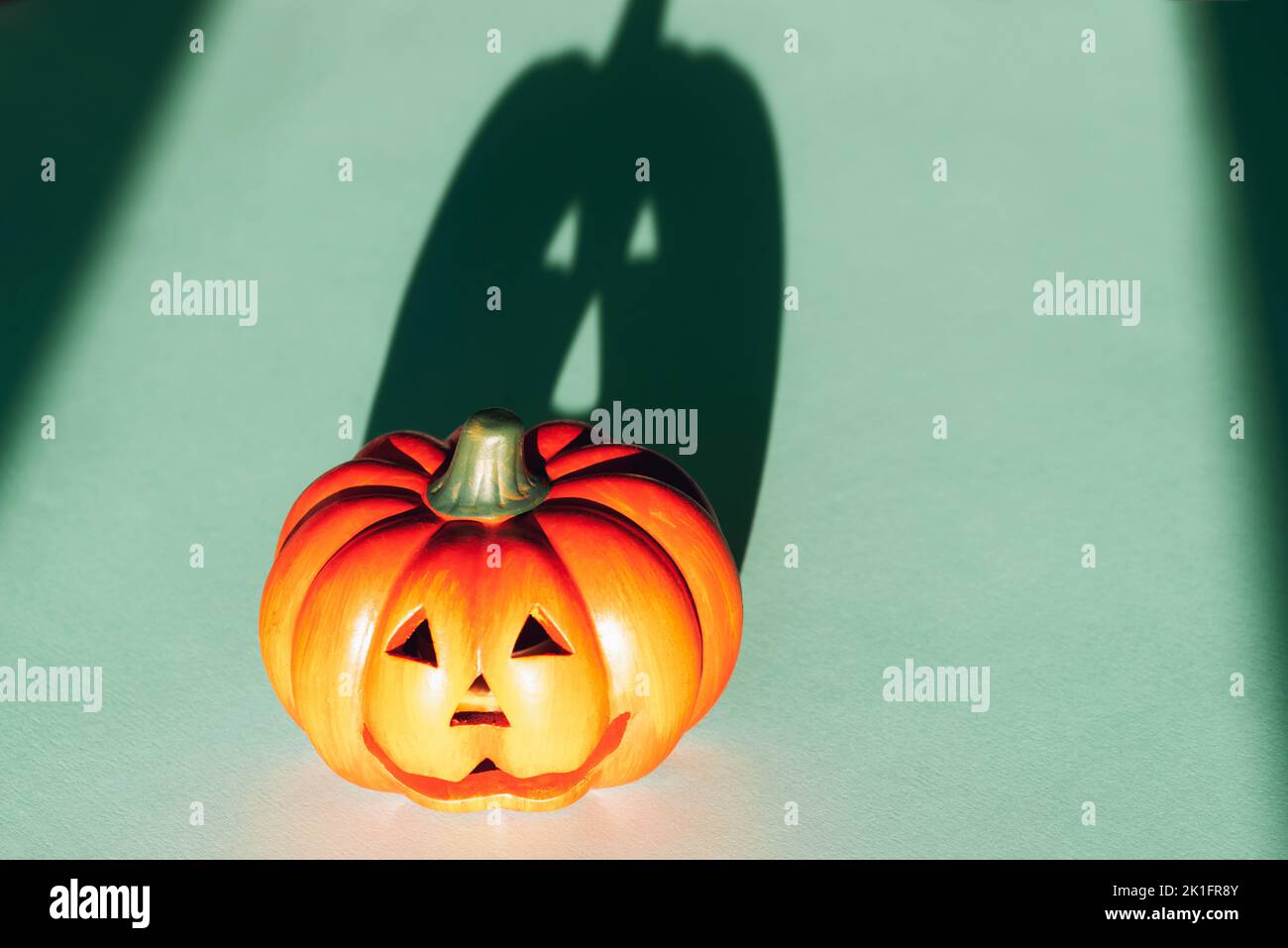 Jack-O-Lantern avec forte ombre sur fond bleu. Concept Halloween. Banque D'Images