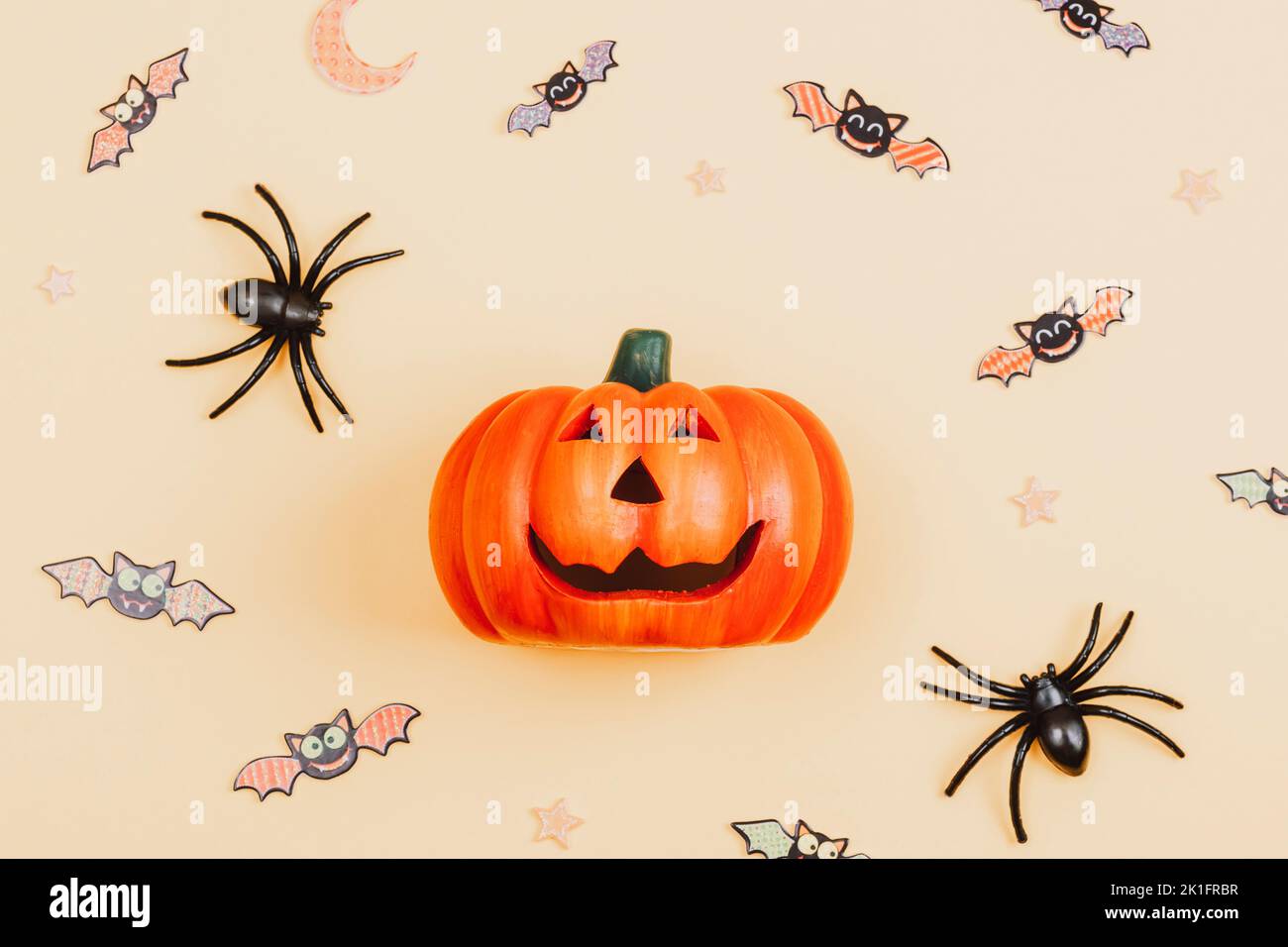 Lanterne, araignées et chauves-souris à motif citrouille d'Halloween Jack O sur fond orange clair. Vue de dessus, plat, espace de copie. Banque D'Images
