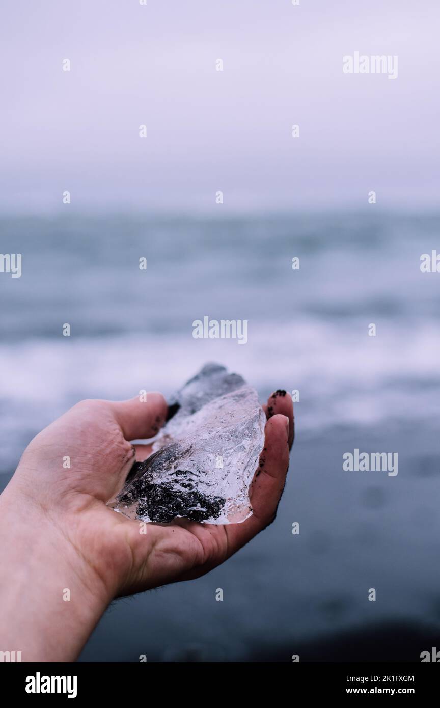 Homme voyageur tenant un petit morceau de glacier dans sa main Banque D'Images