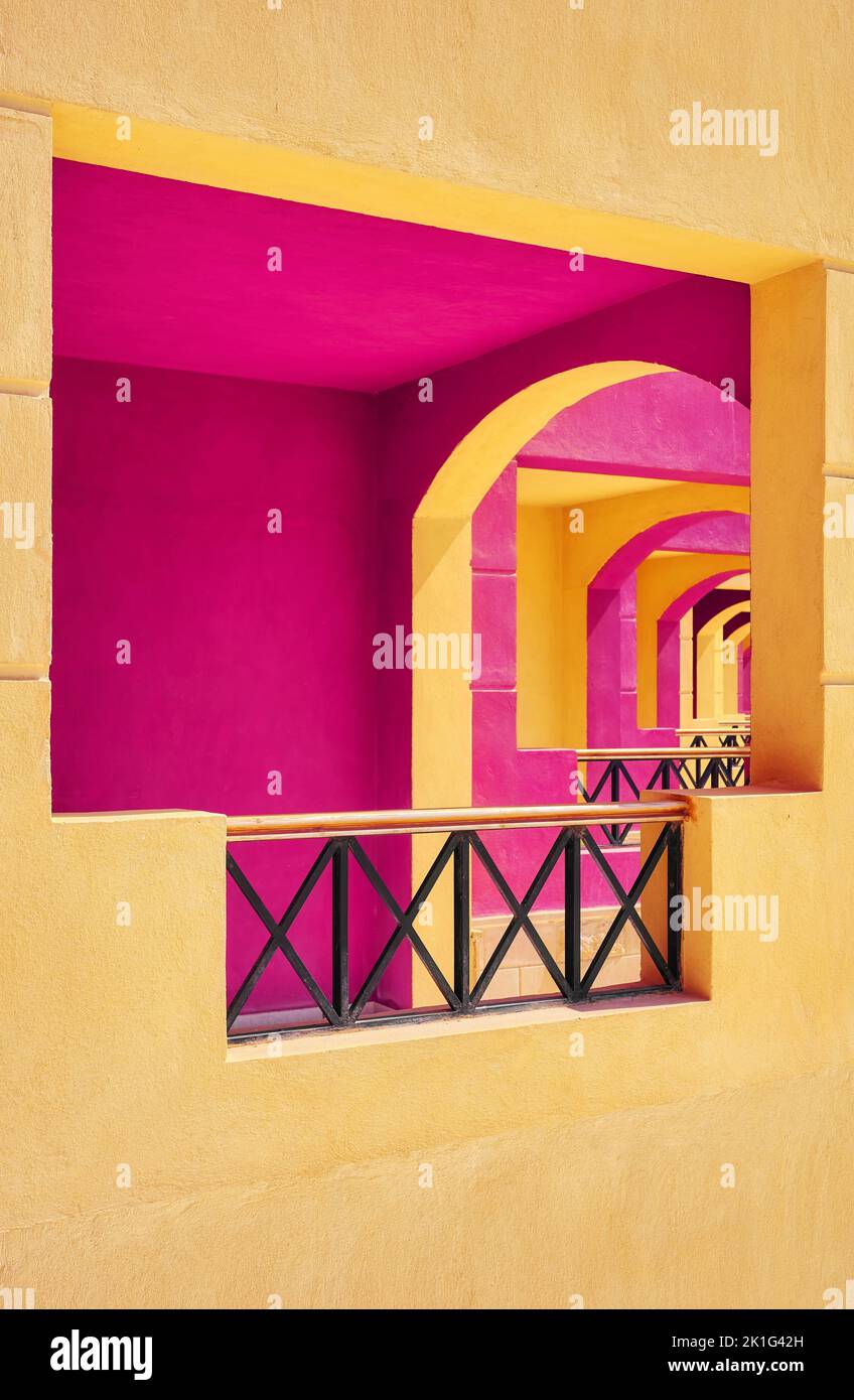 Façade de bâtiment peinte en rose et jaune, mise au point sélective, arrière-plan de l'architecture. Banque D'Images