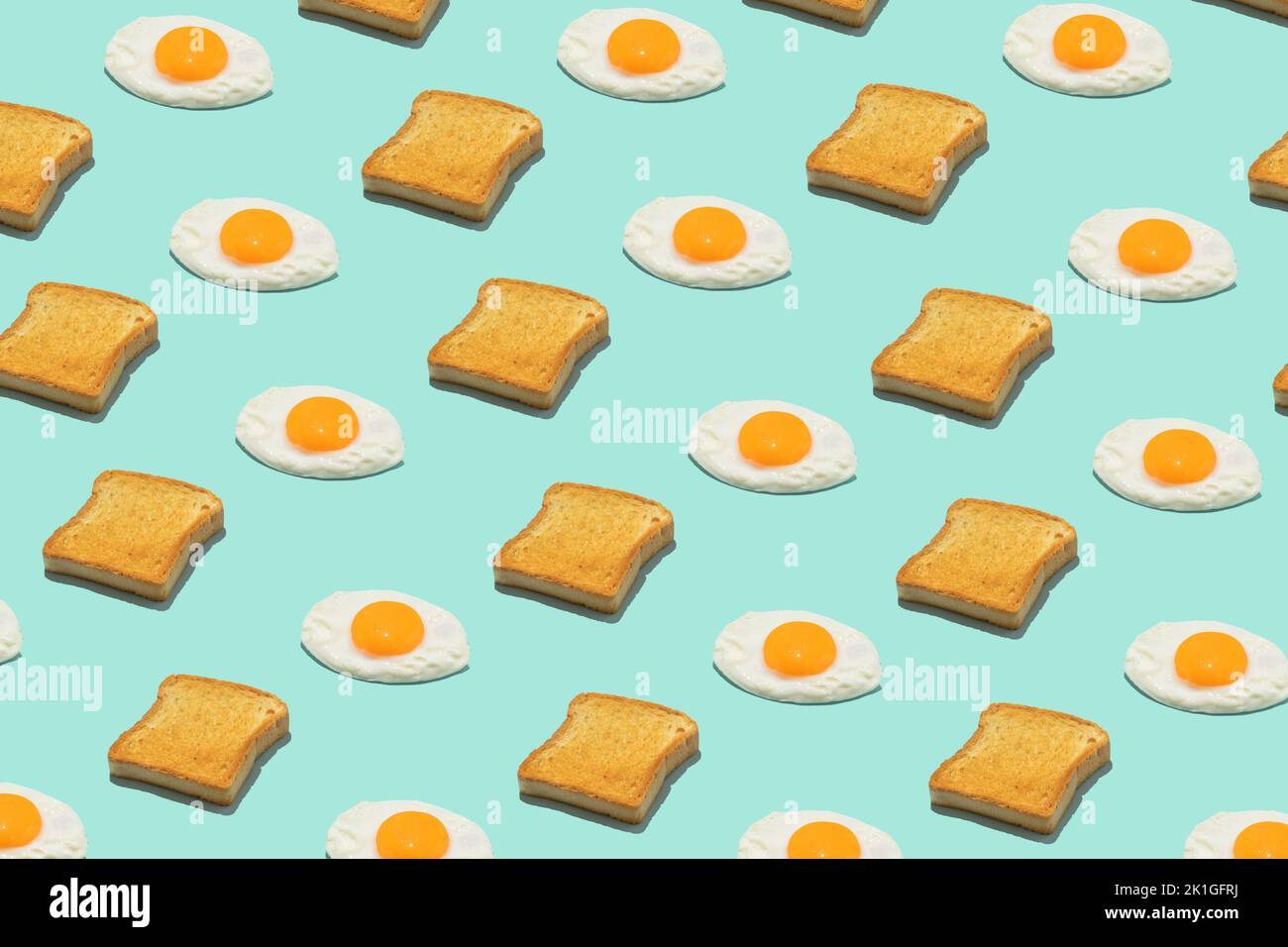 Un modèle d'alimentation créatif sans couture. Œufs et toasts frits sur fond bleu. Petit déjeuner amusant et coloré. Banque D'Images