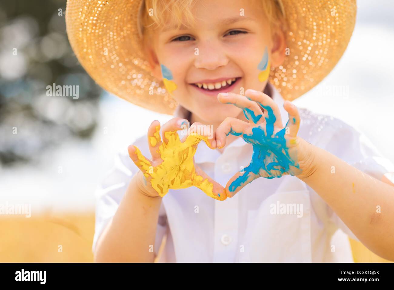 Arrêtez la guerre en Ukraine. Un garçon ukrainien avec drapeau ukrainien - jaune et bleu peint sur les mains se tient contre la guerre. Banque D'Images