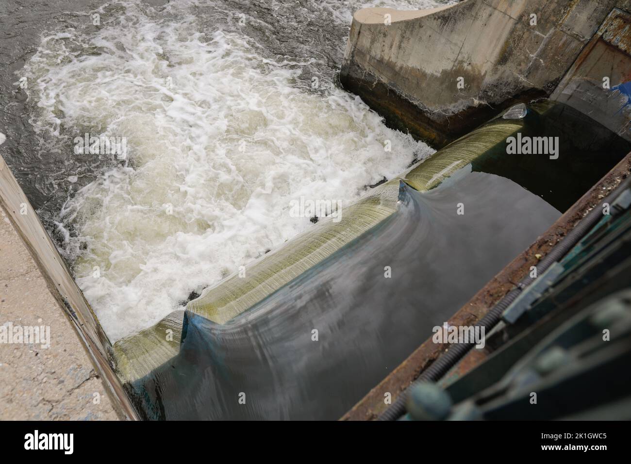 Eau qui coule à travers un bidonville sur une rivière. Banque D'Images