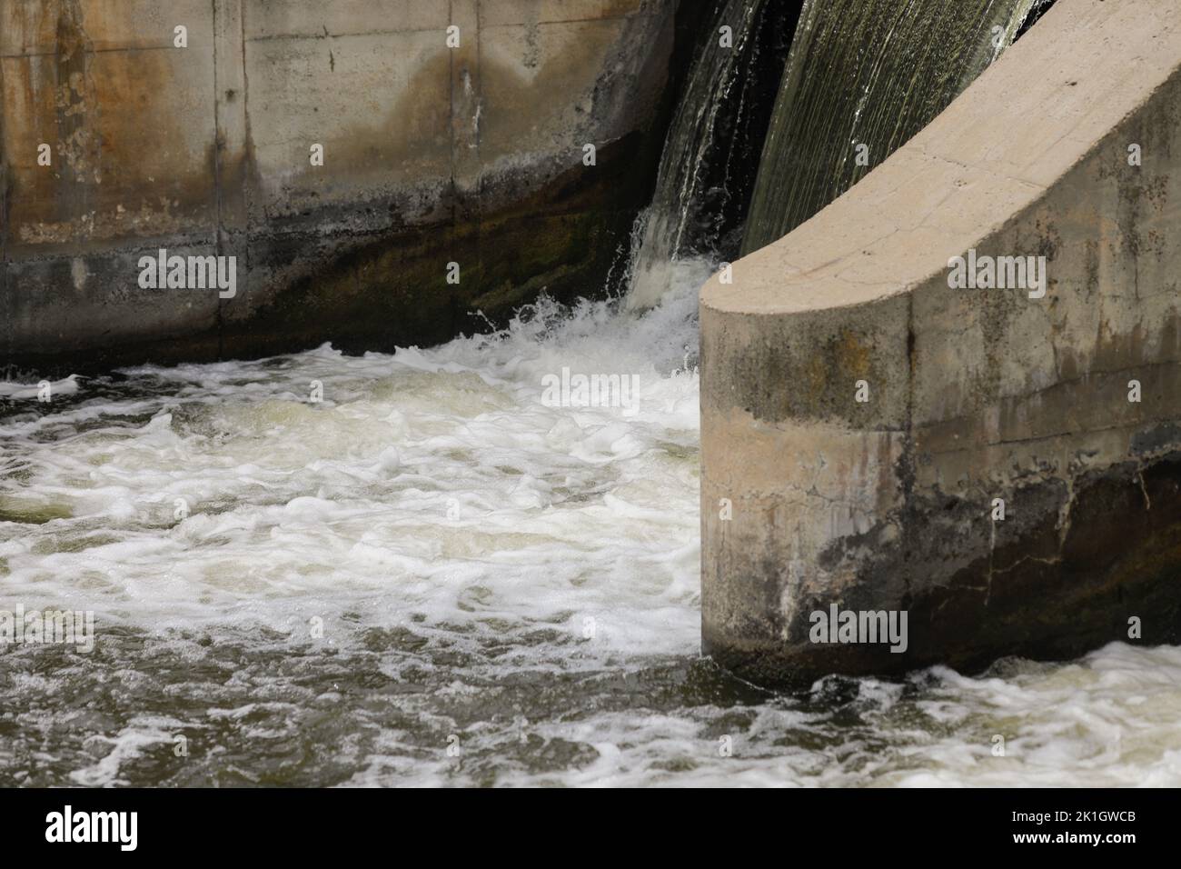 Eau qui coule à travers un bidonville sur une rivière. Banque D'Images