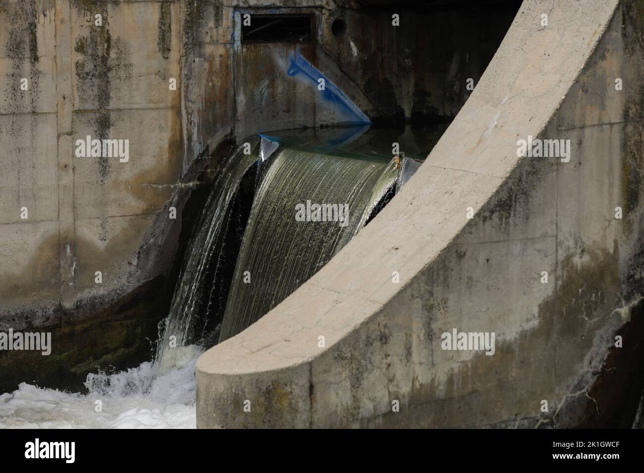 Eau qui coule à travers un bidonville sur une rivière. Banque D'Images