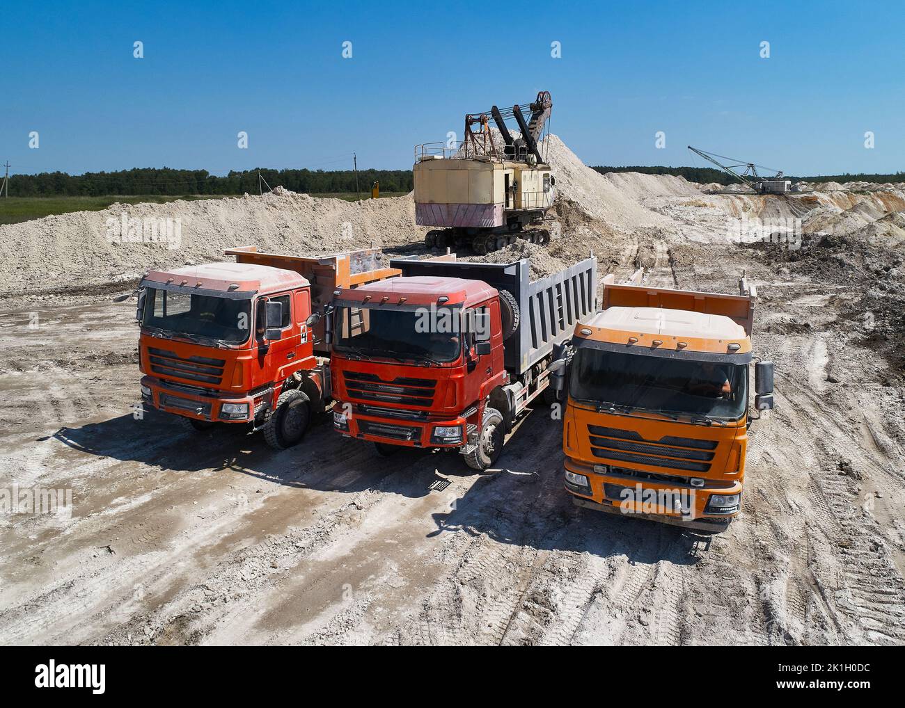 Des camions et des pelles hydrauliques à pointes colorées à ChalkQuarry en été Banque D'Images