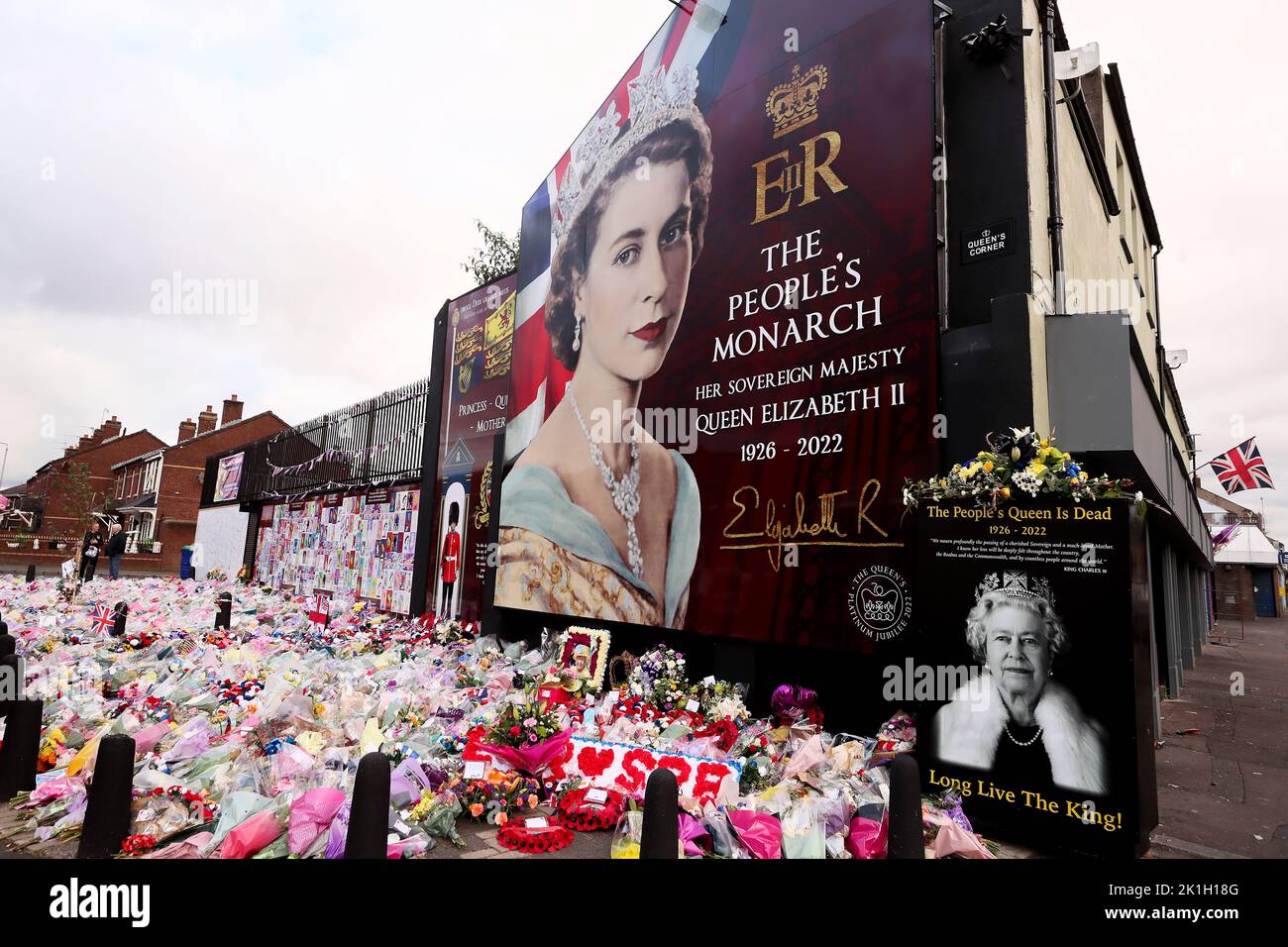 Les gens labouent des fleurs à une fresque représentant la reine Elizabeth II sur la route Shankill à Belfast après le décès du monarque britannique. Banque D'Images