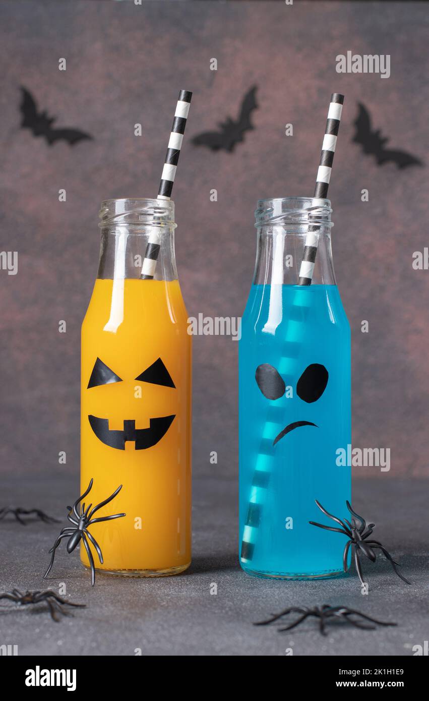 Deux boissons colorées pour Halloween en bouteilles pour la fête des enfants sur fond marron Banque D'Images