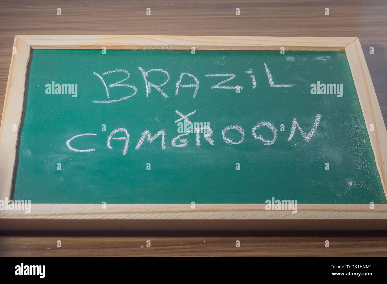 Tableau vert écrit 'Brésil x Camerron' avec une craie blanche, concept de confrontation entre pays, football. Banque D'Images