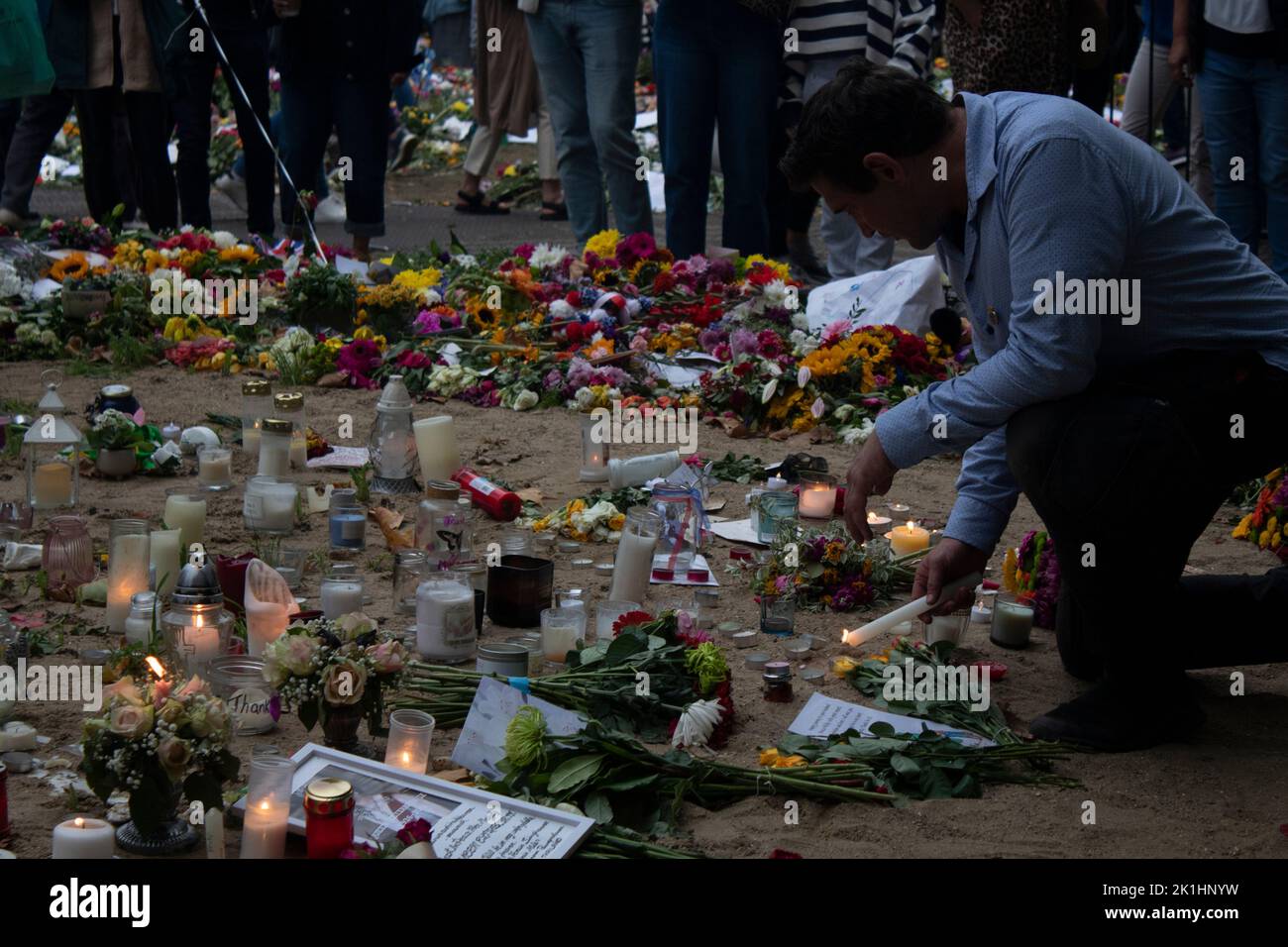 Homme éclairant des bougies, parmi des messages, des cartes et des hommages floraux à Green Park après la mort de la reine Elizabeth, 18 septembre 2022, Londres, Angleterre Banque D'Images