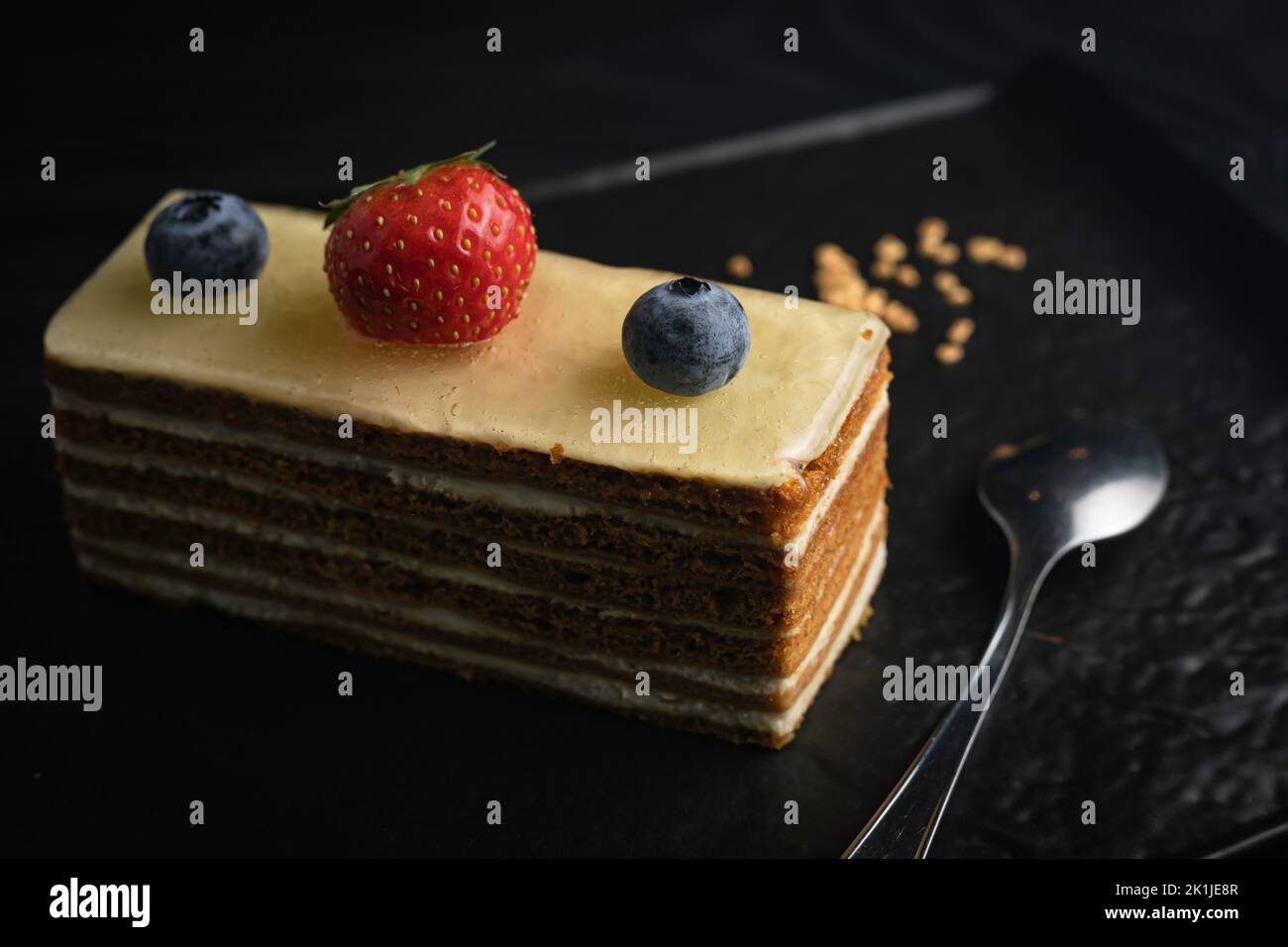 Un gros plan d'un gâteau de l'Opéra avec des baies servies sur une assiette Banque D'Images