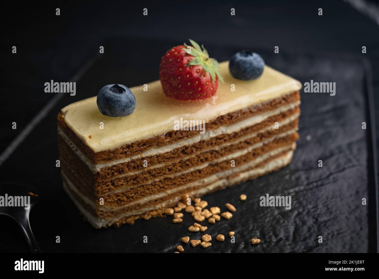 Un gros plan d'un gâteau de l'Opéra avec des baies servies sur une assiette Banque D'Images