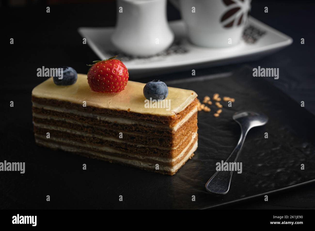 Un gros plan d'un gâteau de l'Opéra avec des baies servies sur une assiette Banque D'Images