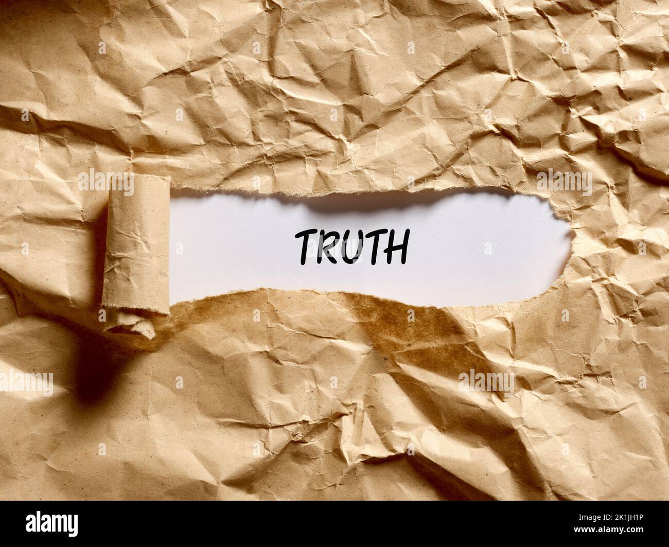 Le mot vérité écrit sous un papier déchiré marron. Pour révéler, exposer, découvrir ou afficher le concept de vérité sous-jacent caché. Banque D'Images