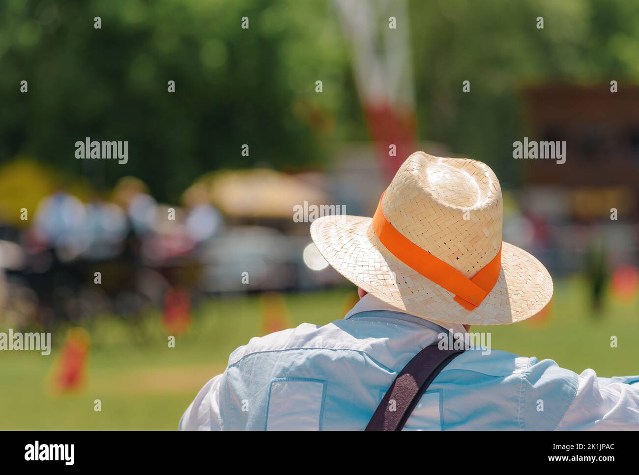 Groupe de personnes décontractées méconnues portant des chapeaux de paille avec un groupe d'orange lors d'un événement public équestre en direct le jour ensoleillé de l'été, attention sélective Banque D'Images