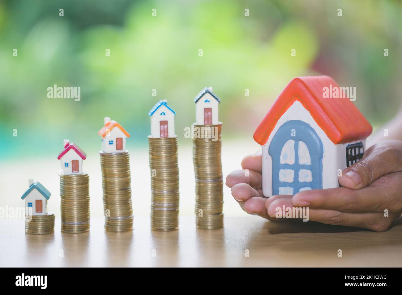 Protection des mains, modèle de maison sur la pile d'argent comme croissance du crédit hypothécaire, concept de gestion de propriété. Gestion des risques et des invasions. Banque D'Images