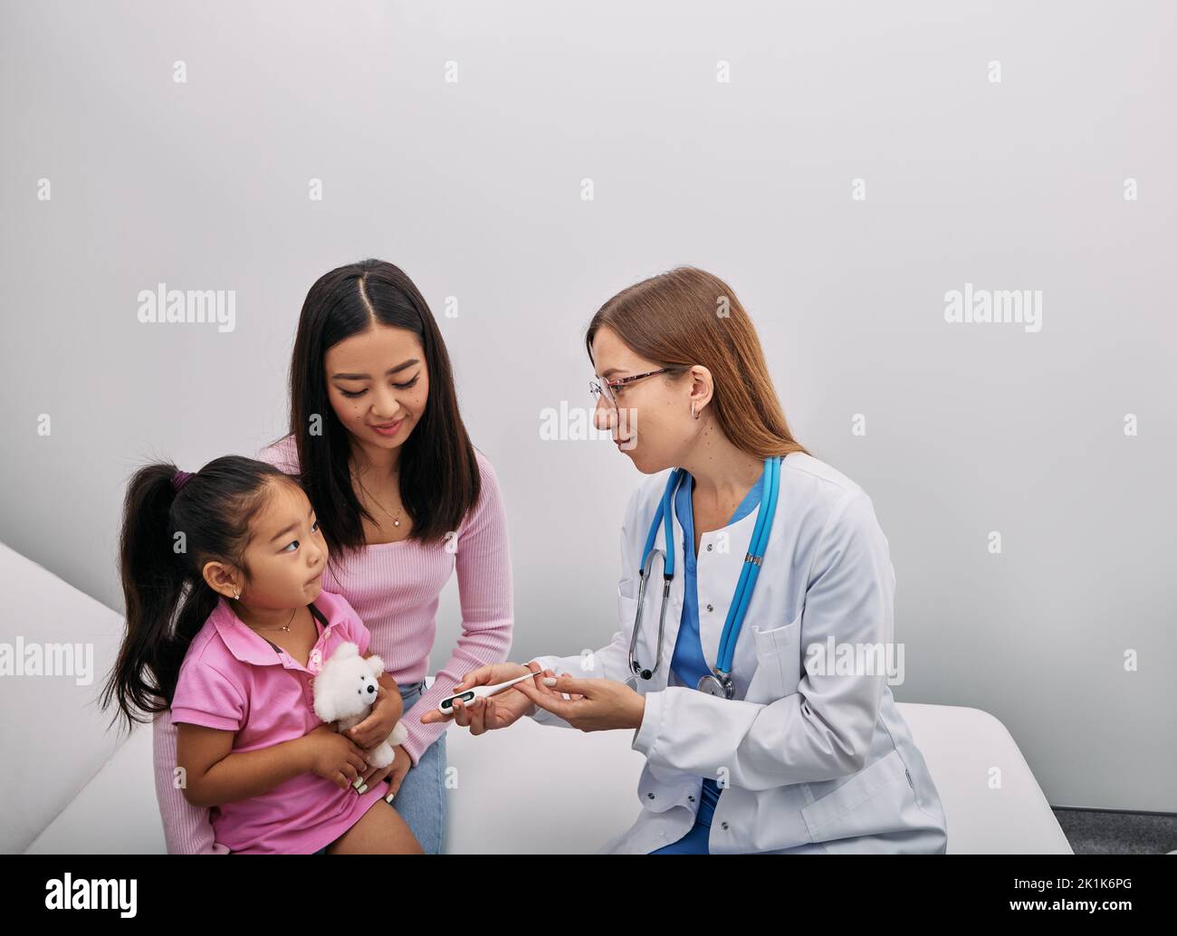 Parent japonais avec une femme enfant pendant un examen médical à l'hôpital. Consultation pédiatre Banque D'Images