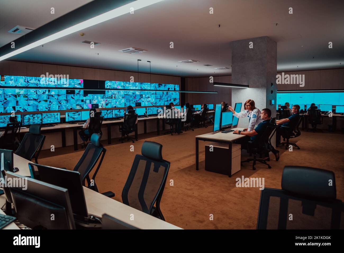 Groupe d'opérateurs de centre de données de sécurité travaillant dans une salle de surveillance CCTV regardant sur plusieurs moniteurs officiers surveillant plusieurs écrans Banque D'Images