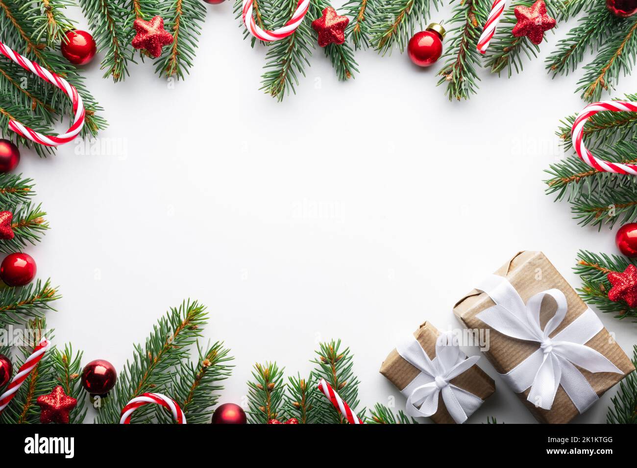 Fond de Noël créatif avec boules de Noël, brindilles de pin et décorations étoiles dorées sur fond blanc. Flat lay, vue de dessus, espace de copie Banque D'Images