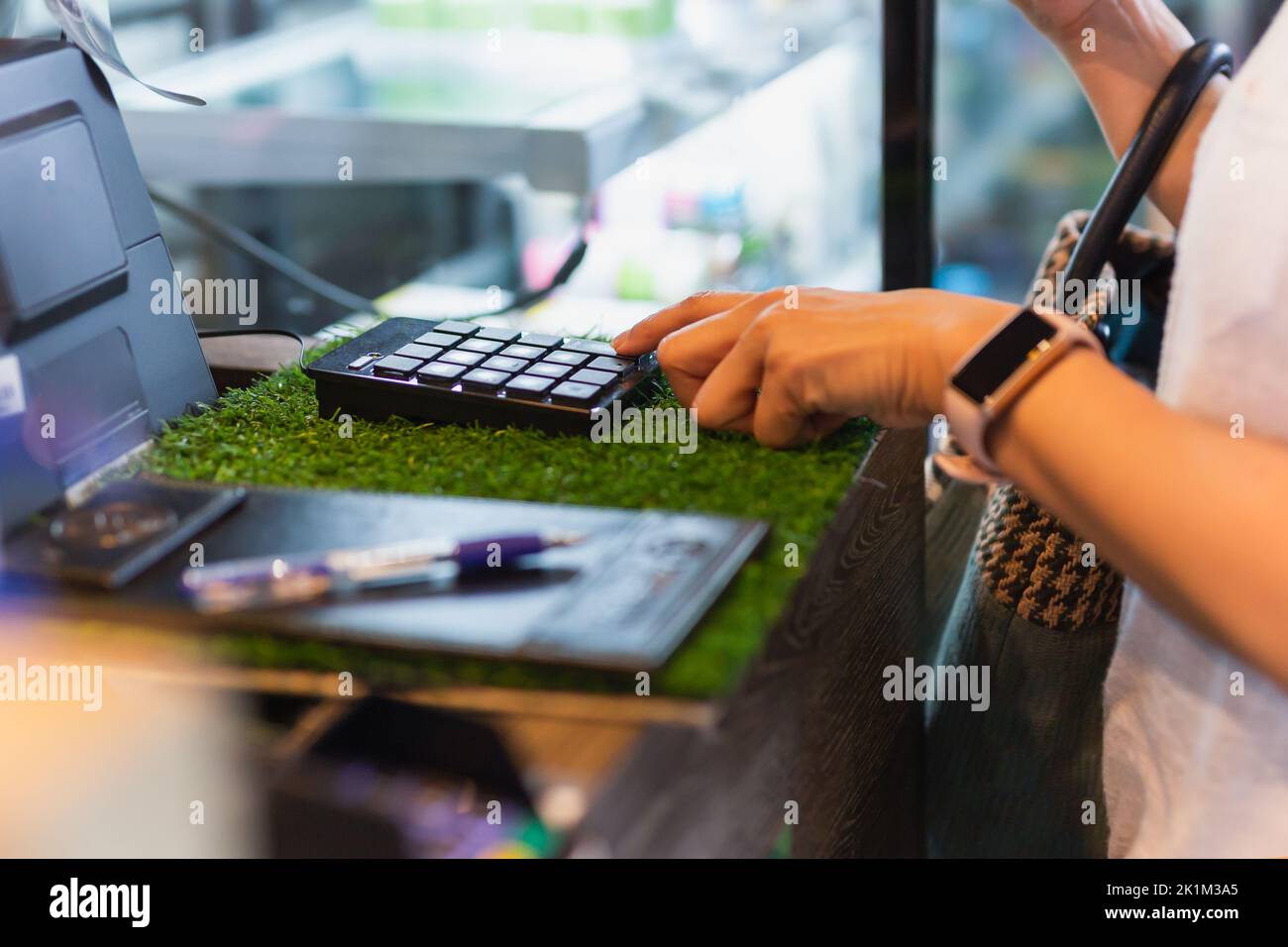 Woman costomer entre le montant dans la caisse du café. Banque D'Images