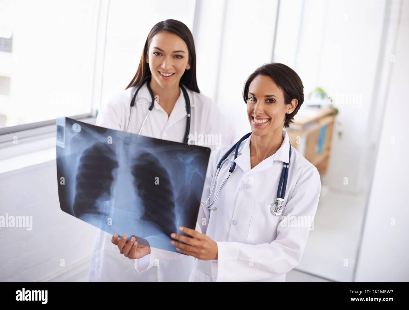Leur pronostic est bon. Une paire de jeunes médecins envisageant une radiographie. Banque D'Images