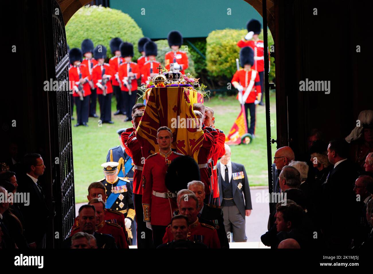 Le roi Charles III (à gauche) suit alors que les porteurs de cercueils transportent le cercueil de la reine Elizabeth II dans la chapelle Saint-Georges du château de Windsor, dans le Berkshire, pour le service de committal. Date de la photo: Lundi 19 septembre 2022. Banque D'Images