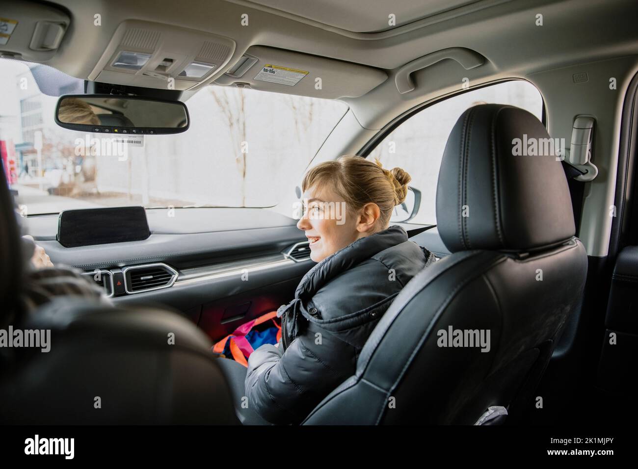 Une adolescente dans un ensemble de voitures de passagers souriant Banque D'Images