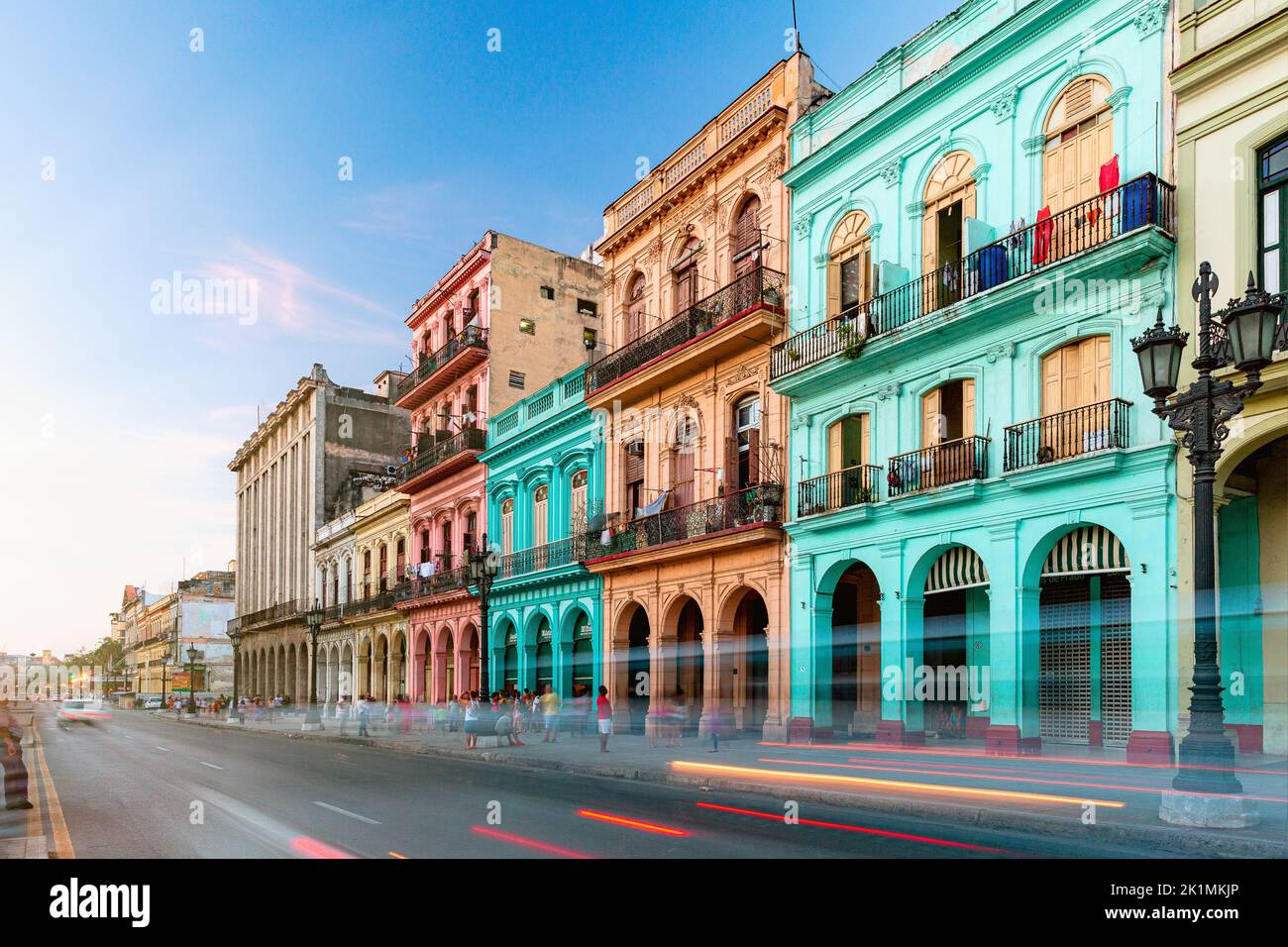 Une longue exposition de voitures passant avec de vieux bâtiments historiques colorés en arrière-plan à la Havane, Cuba Banque D'Images