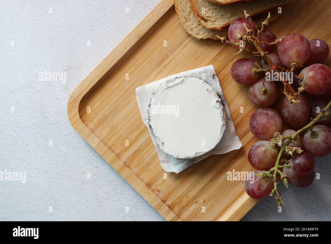 vue de dessus du fromage de chèvre frais et des fruits à raisin sur fond de bois. Banque D'Images