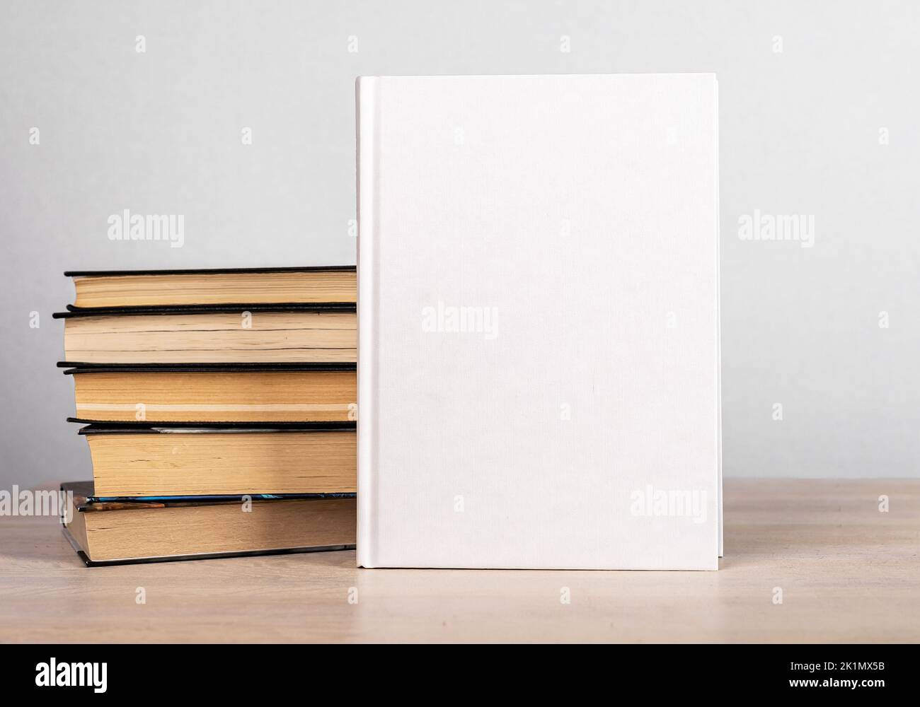 La maquette et les romans s'empilent sur une table en bois. Modèle avec couverture blanche. Littérature, éducation, concept de lecture. Publicité du nouveau volume. Bonjour Banque D'Images