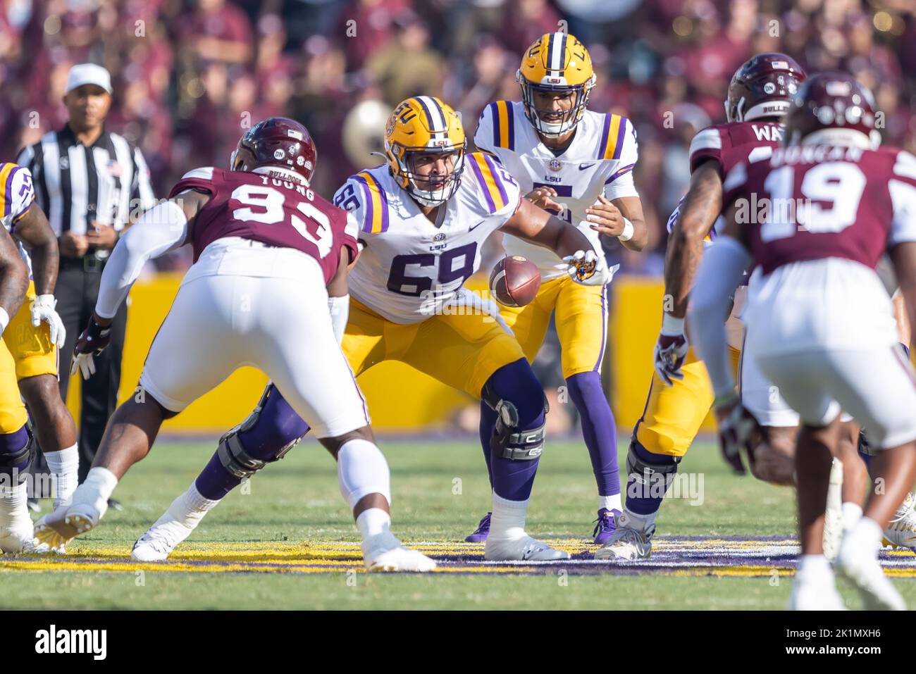 Charles Turner (69), le joueur de ligne offensif des Tigers du LSU, encadre le ballon pour le quarter back Jayden Daniels (5) contre les Bulldogs de l'État du Mississippi, samedi, se Banque D'Images