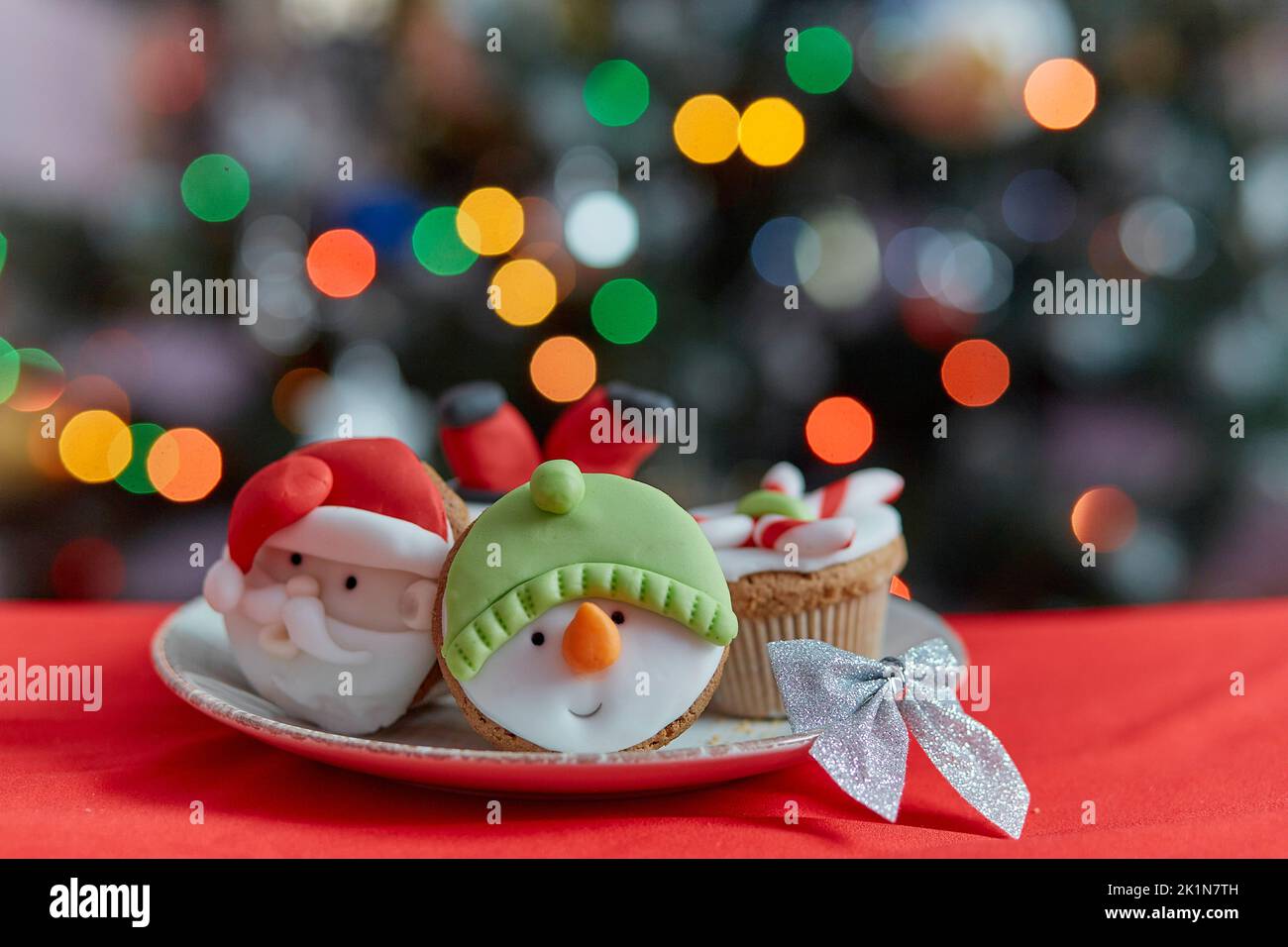 Petits gâteaux de Noël confortables. Petits gâteaux décoratifs et créatifs devant l'arbre de Noël. Bonne humeur, fêtes de fin d'année. Mise au point sélective Banque D'Images