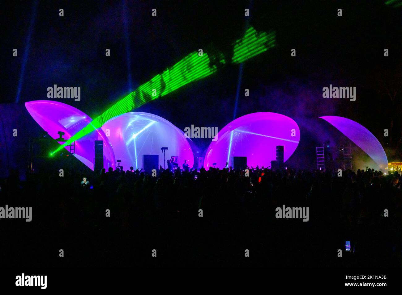 Des lumières laser colorées brillent et se déplacent sur la foule dansante pendant la fête du DJ Banque D'Images