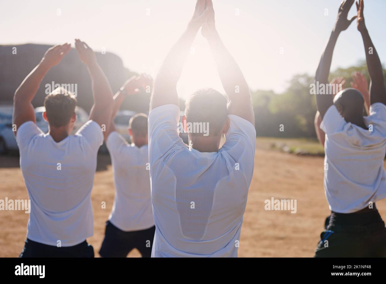 Se mettre en forme avec l'aide de bootcamp. Vue arrière d'un groupe d'hommes effectuant des exercices dans un camp militaire de démarrage Banque D'Images