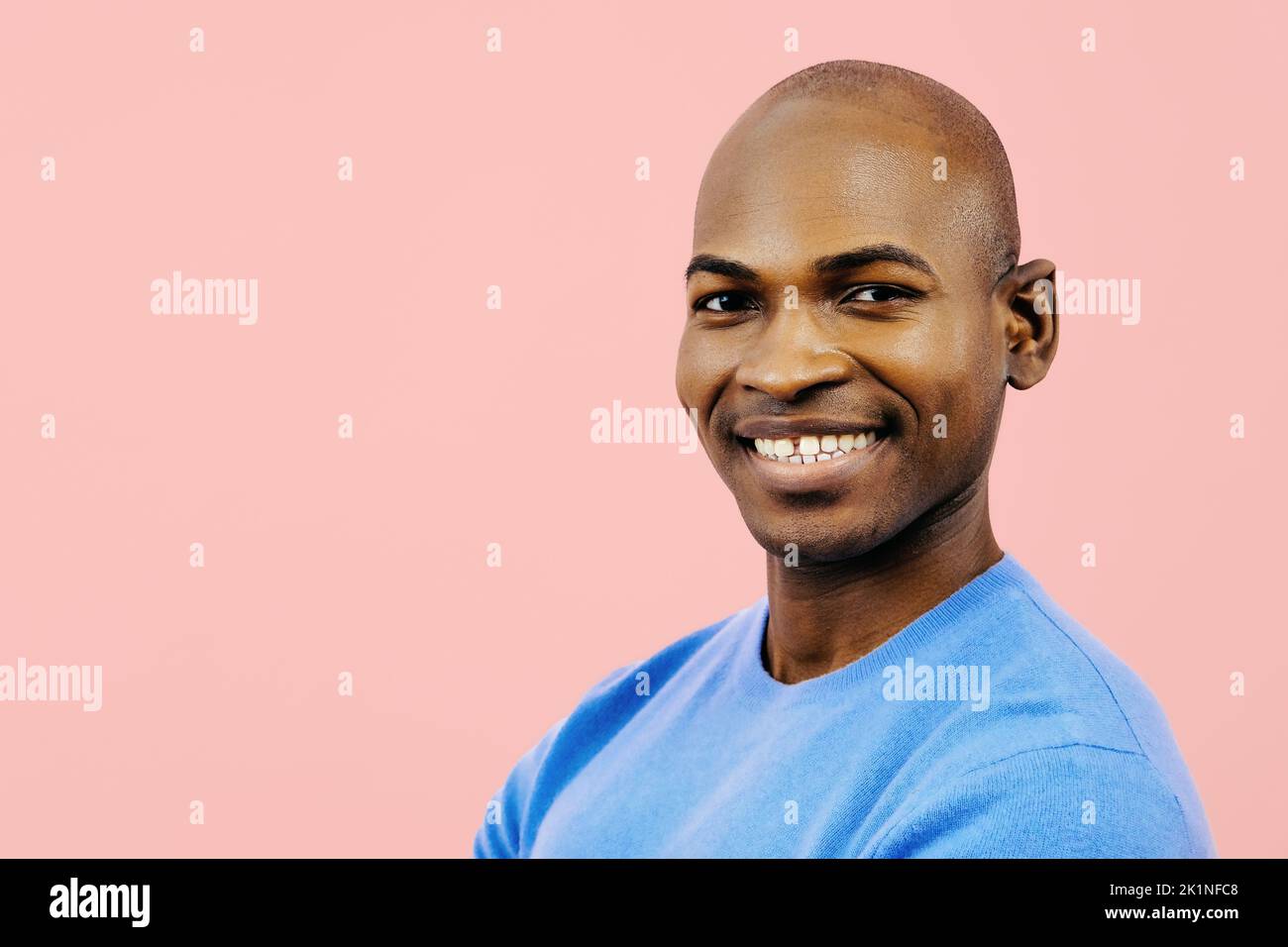 un homme souriant qui regarde l'appareil photo à l'intérieur d'un studio Banque D'Images