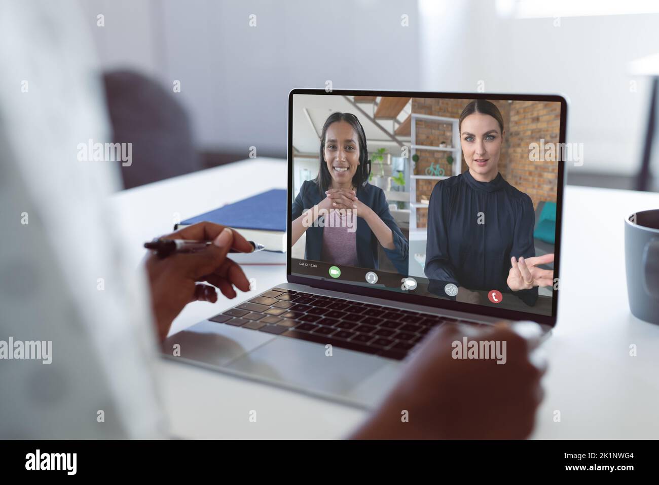 Les mains rognées d'une femme afro-américaine discutant avec des collègues de sexe féminin sur vidéocall Banque D'Images