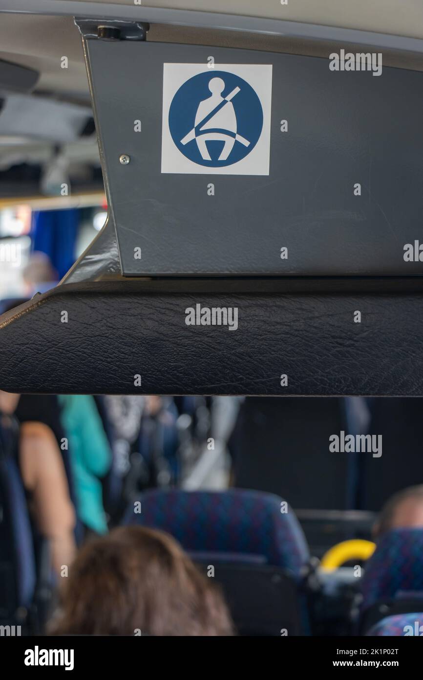 L'intérieur d'un bus avec le pictogramme d'un passager se fixe avec la ceinture à un siège Banque D'Images