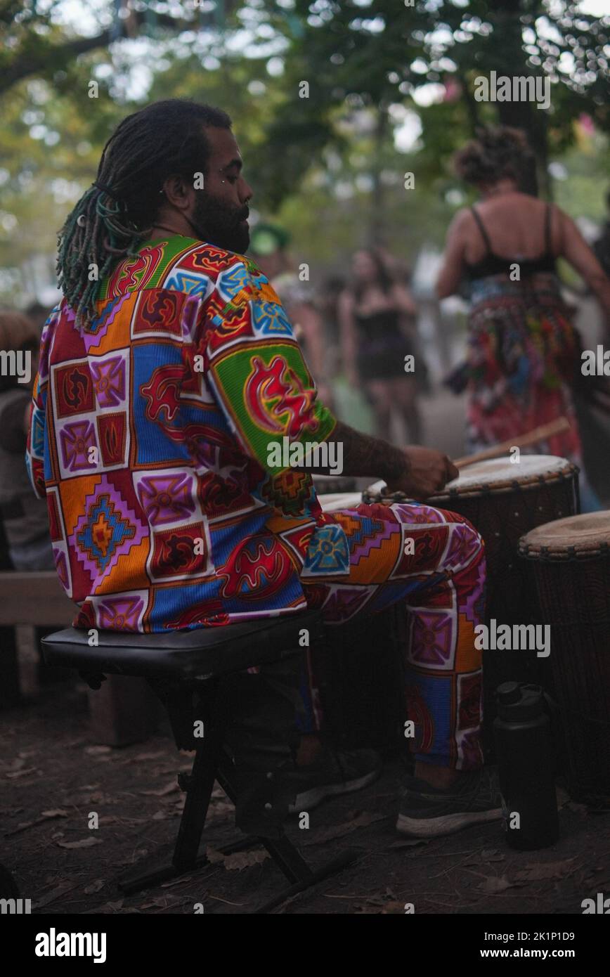 Homme jouant des tambours africains dans des vêtements traditionnels colorés Banque D'Images Homme jouant des tambours africains dans des vêtements traditionnels colorés Banque D'Images