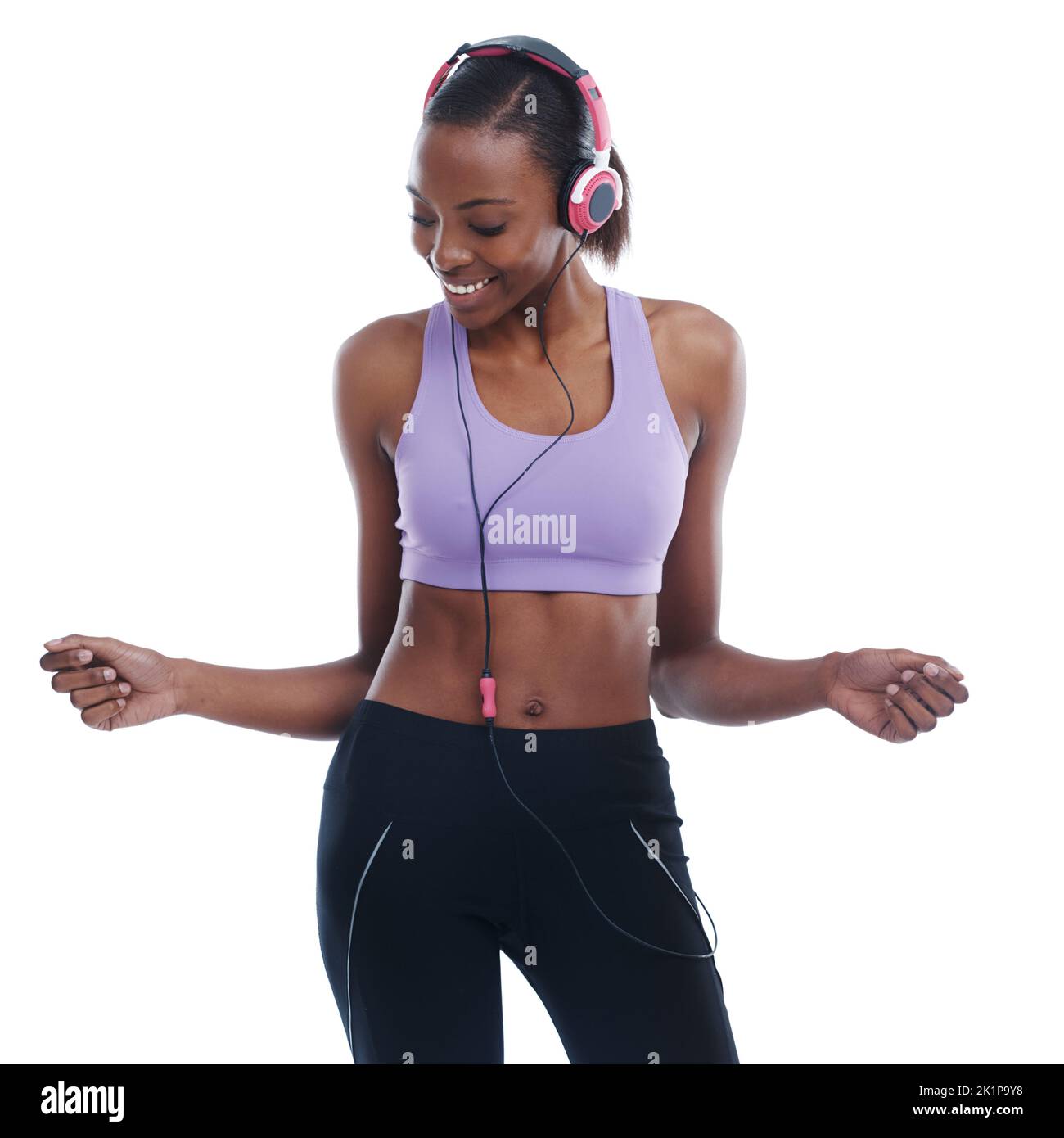 Bonne musique son secret à une grande séance d'entraînement. Une belle jeune femme en vêtements de sport danse volontiers à la musique dans son casque Banque D'Images