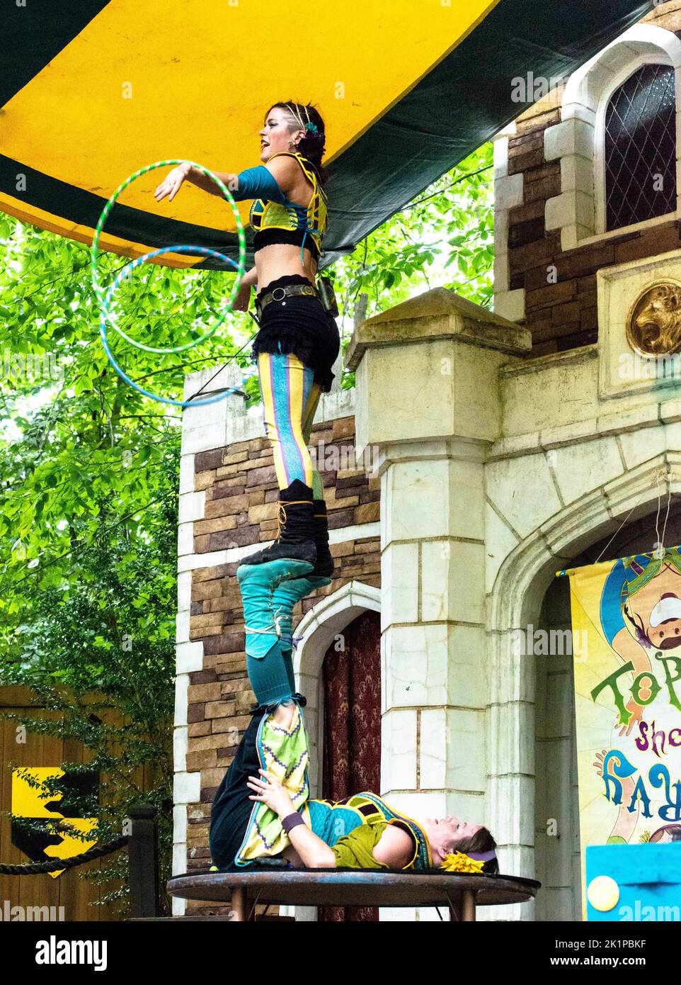 Topsy Turvy Show, 2 acrobates féminins se exécutant au Maryland Renaissance Festival, Crownsville, MD, 2022. Le jongleur de Hoop debout sur les partenaires a relevé les pieds. Banque D'Images