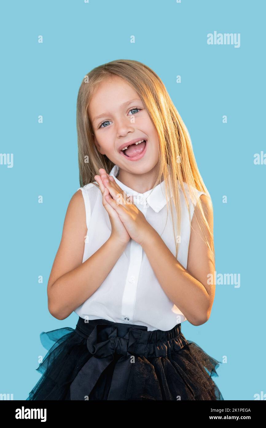 Enfant amusé. Une surprise parfaite. Réaction de Wow. Portrait de la petite fille heureuse impressionnée dans une tenue élégante profitant du moment souriant isolé sur le backgro bleu Banque D'Images