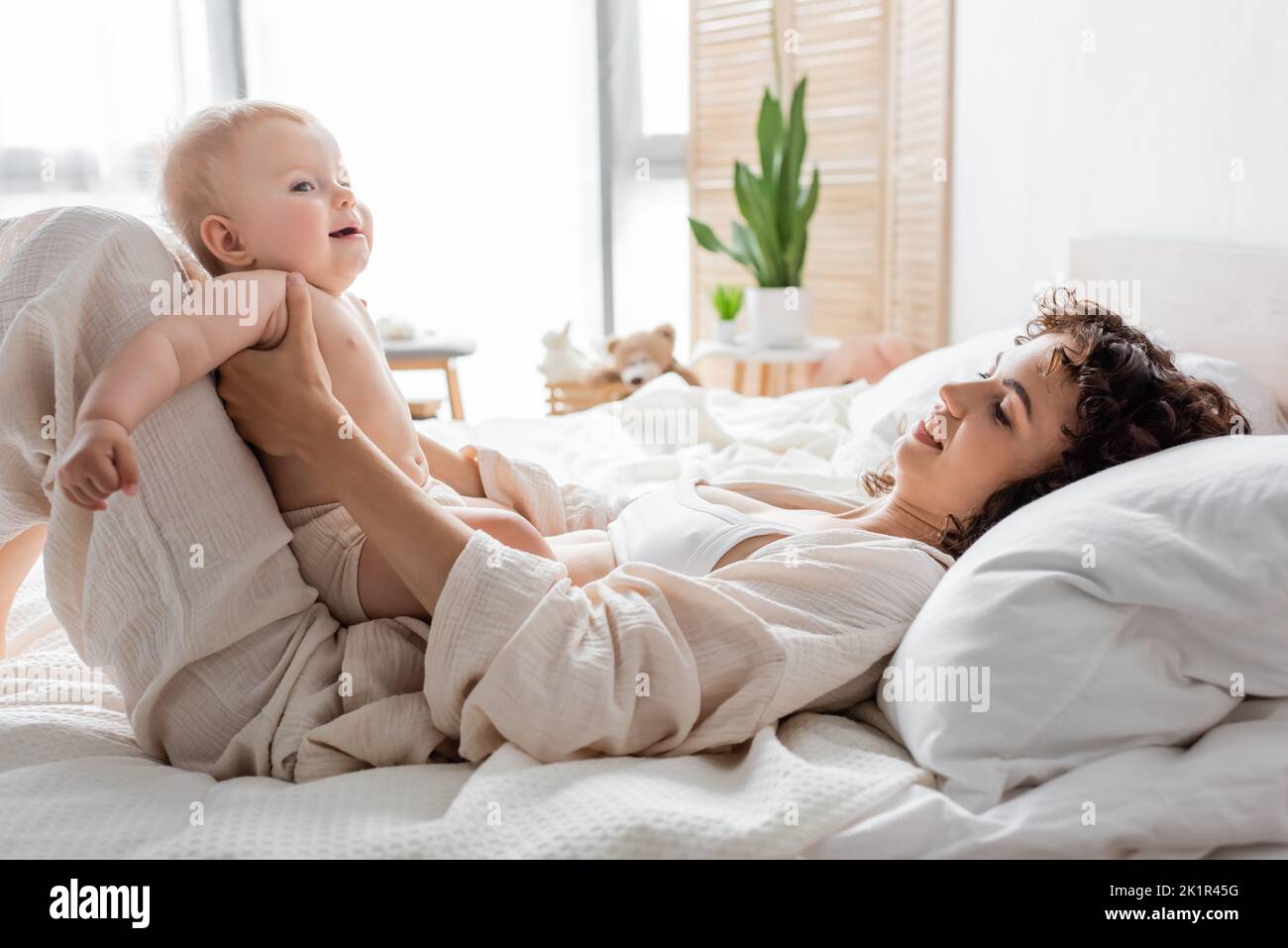 bonne femme en chaise longue couchée sur le lit avec petite fille, image de stock Banque D'Images