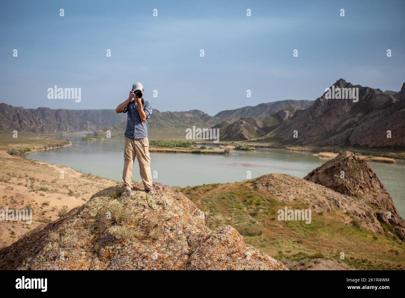 Le photographe photographie un paysage du sommet d'une montagne. Caméraman regarde la caméra avec la caméra Banque D'Images
