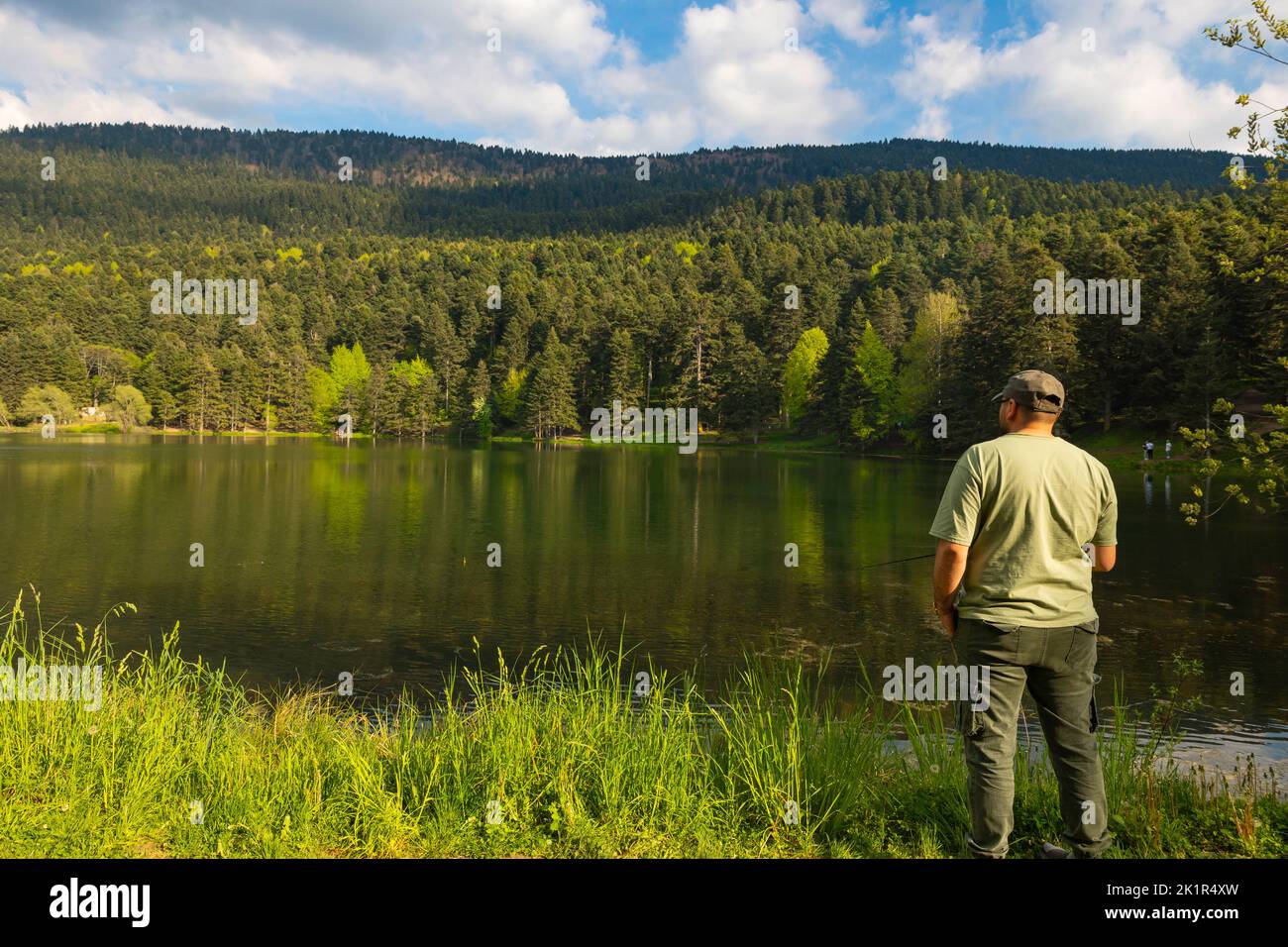 Pêcheur homme pêche près du lac dans la forêt. Photo d'activité de loisir ou de loisir Banque D'Images