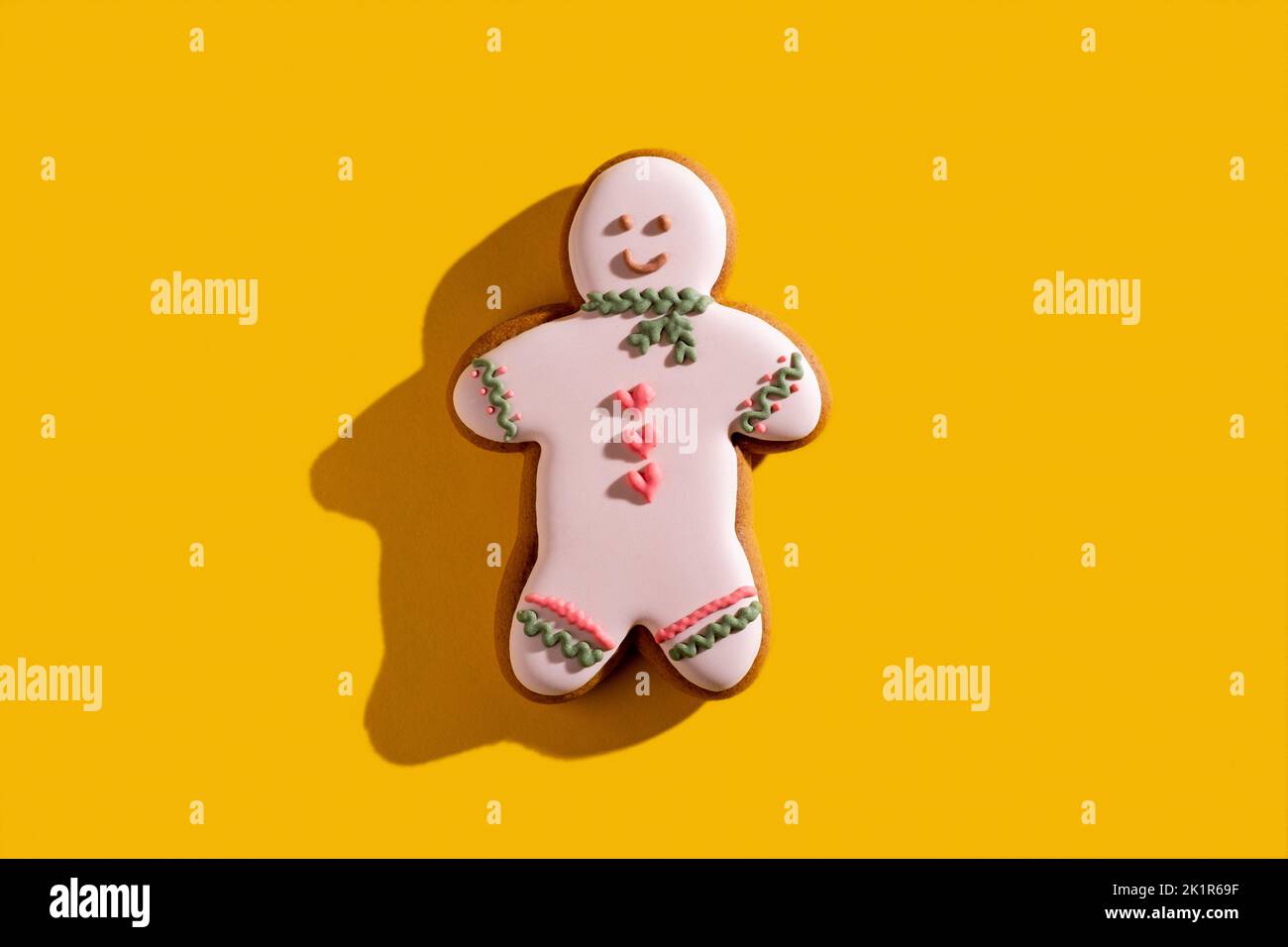 Fierté gay. Fond conceptuel jaune. Solidarité LGBT. Décor de boulangerie. Joyeux rose gay pain d'épice homme cookie avec coeur givrant ornement isolé Banque D'Images
