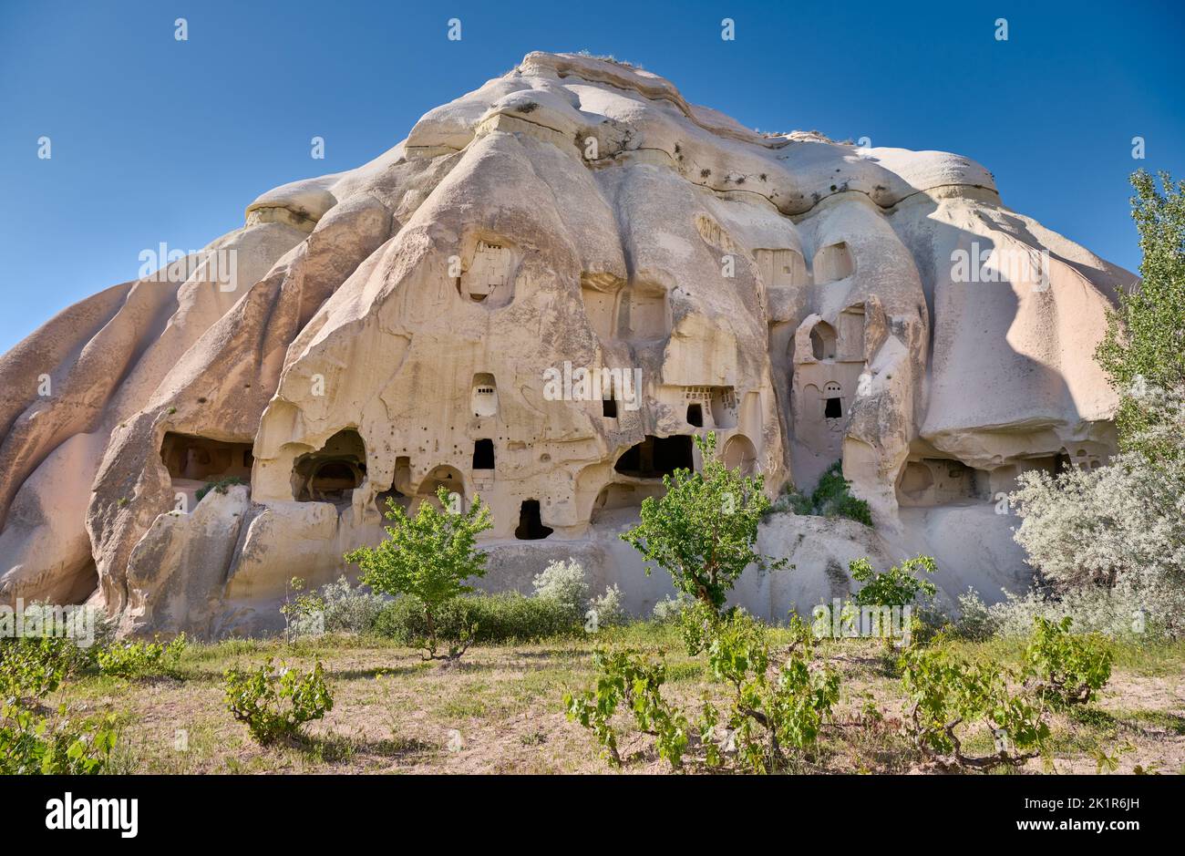Maisons en pierre sculptée ou maisons de grotte dans le paysage de la vallée de la Rose Goreme, Cappadoce, Anatolie, Turquie Banque D'Images