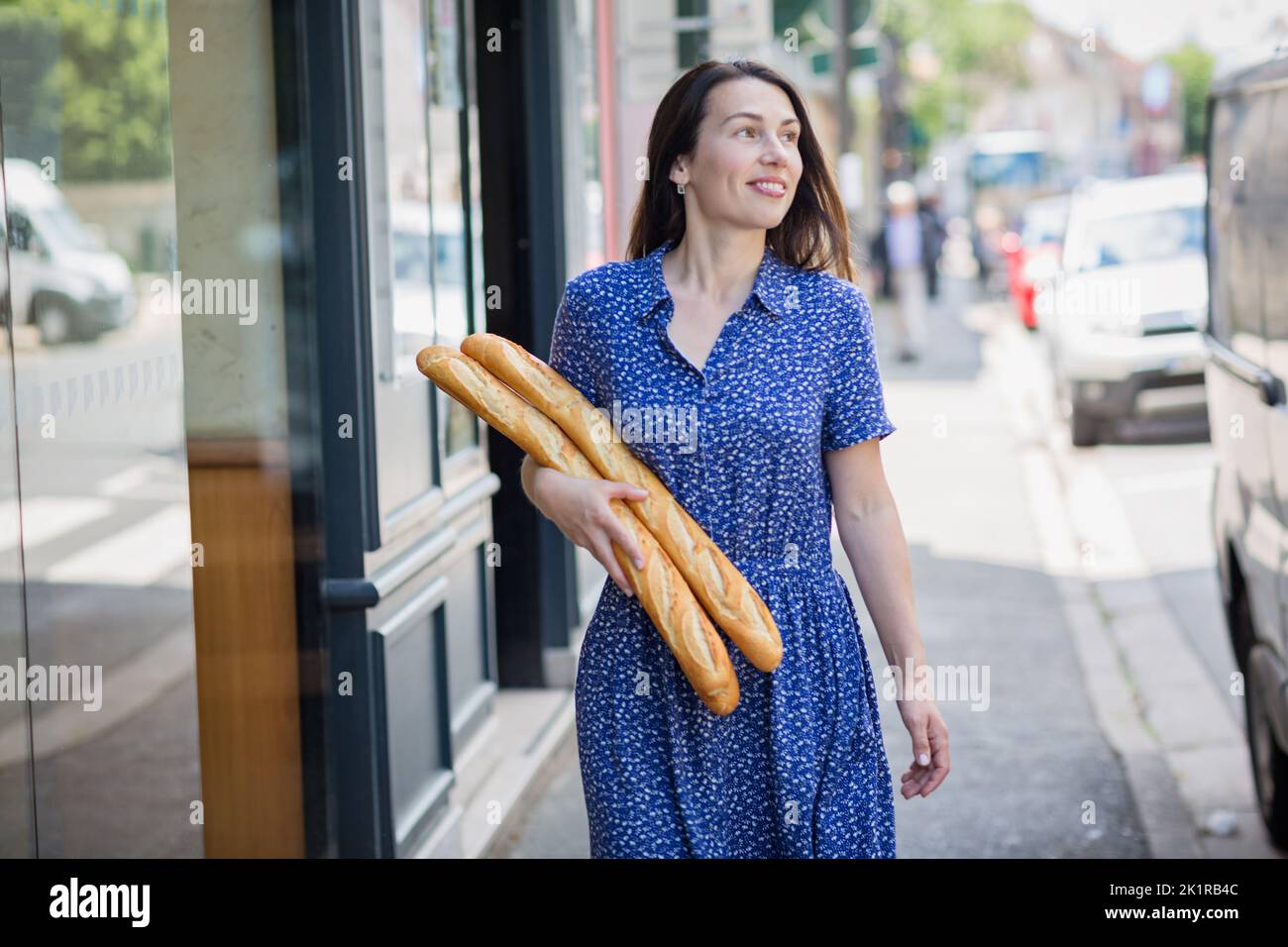 Jeune femme achetant une baguette française Banque D'Images