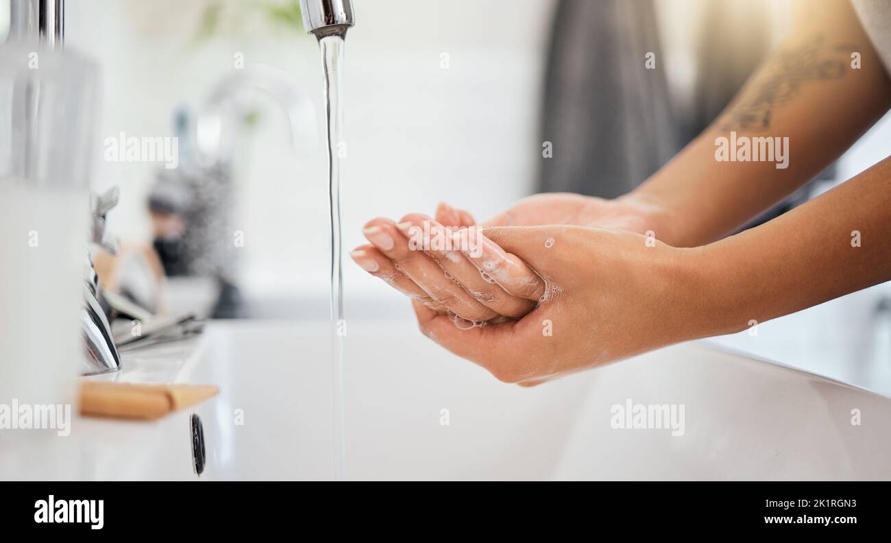 Eau, savon et mains propres de femme dans la salle de bains pour le covid 19, le virus corona ou la sécurité des soins de santé. Nettoyage et bien-être avec une personne se lavant Banque D'Images