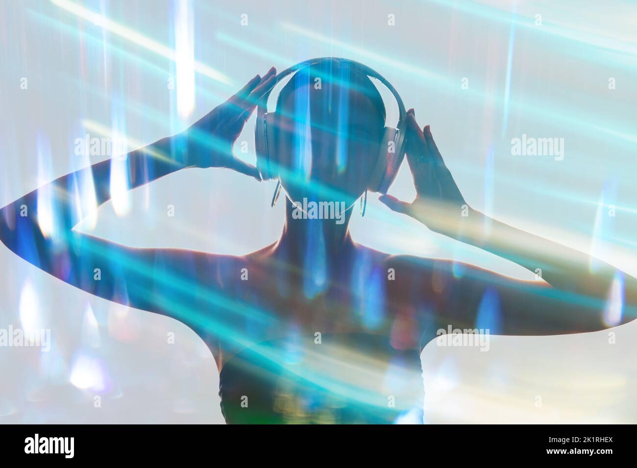 Silhouette à double exposition. Soirée disco. Vie nocturne animée. Portrait en forme de sombre d'une femme DJ écoutant de la musique dans un casque dans un bleu fluo coloré flou Banque D'Images