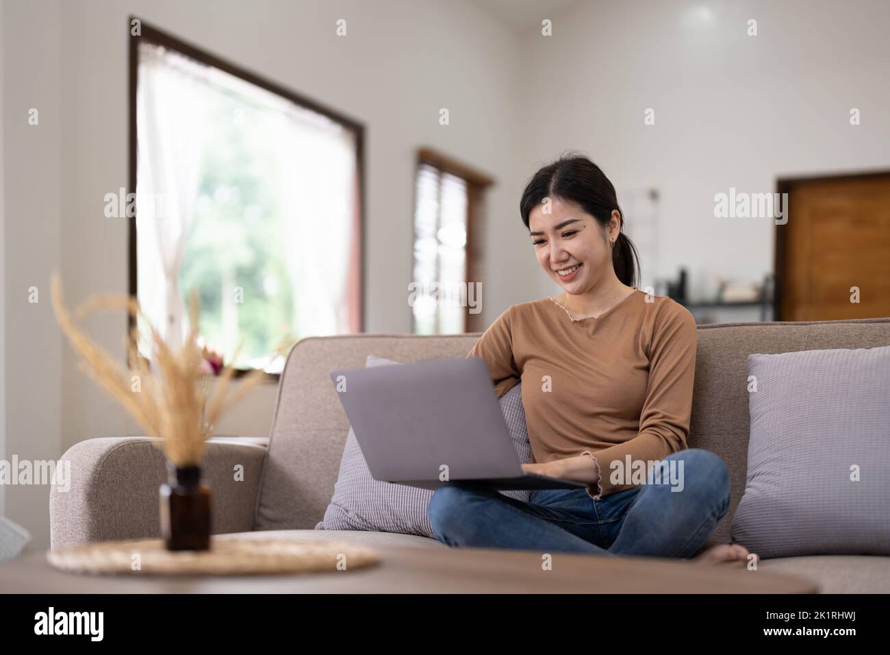 Jeune femme asiatique qui a une conversation en discutant avec un ordinateur portable à la maison. Travail à domicile, visioconférence, appel vidéo de réunion en ligne, virtuel Banque D'Images